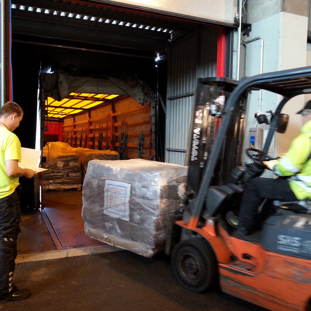 varastointi ja terminaalikäsittely Haminakotka satamassa - warehousing and cargo handling at HaminaKotka harbor, Finland. Pallets unloading from sea container to a warehouse by forklift
