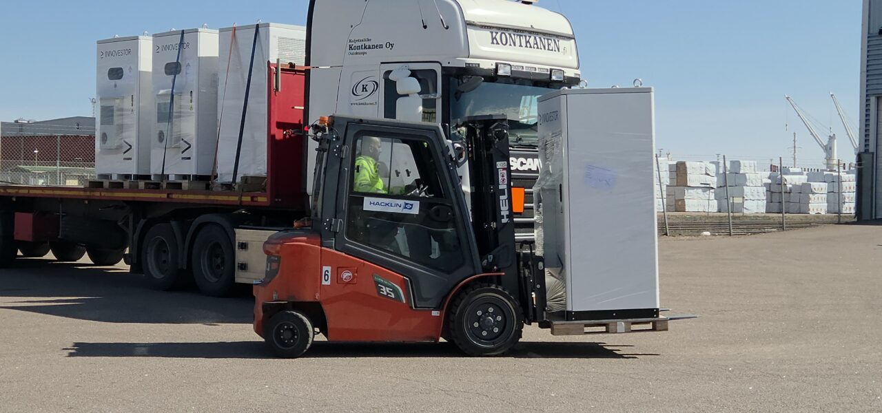 Industrial lithium‑ion battery storage units being loaded at port warehouse in Finland