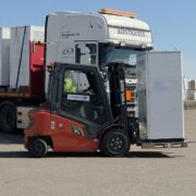 Industrial lithium‑ion battery storage units being loaded at port warehouse in Finland
