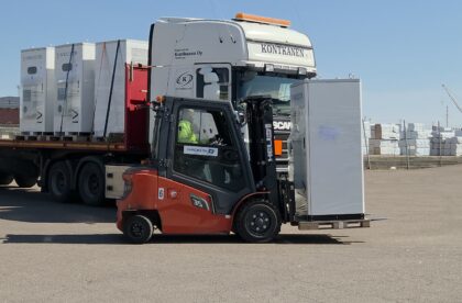 Industrial lithium‑ion battery storage units being loaded at port warehouse in Finland