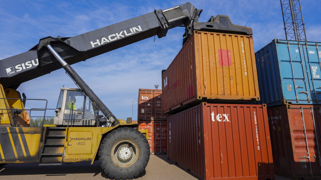Reach stacker handling an intermodal shipping container at a logistics and storage terminal in HaminaKotka, Finland.