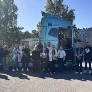 Project participants gathered in front of an electric heavy-duty truck during the ViseLog project final seminar, highlighting innovation and low-emission transport solutions in the logistics industry.